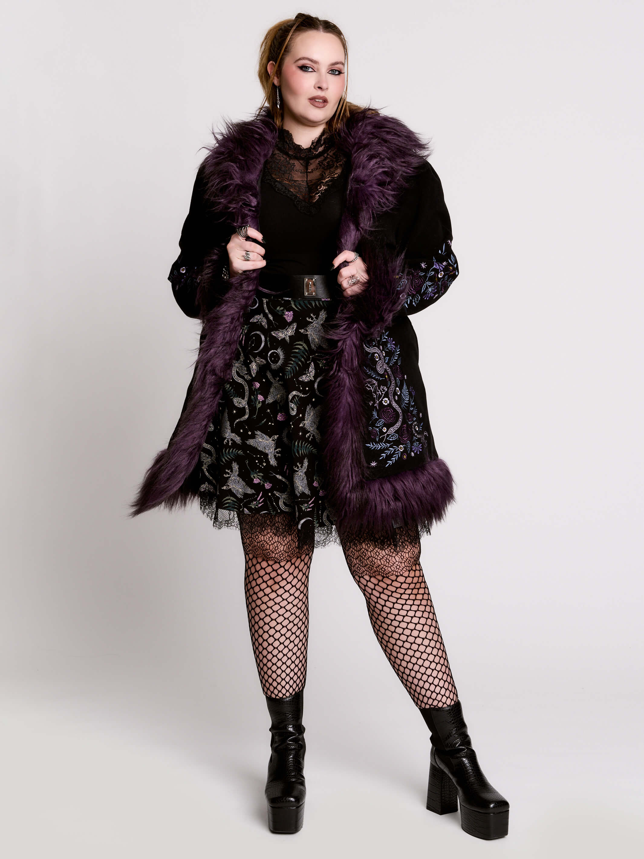 This mid-length black coat pairs a soft, suede-like finish with plush amethyst-purple faux fur trim