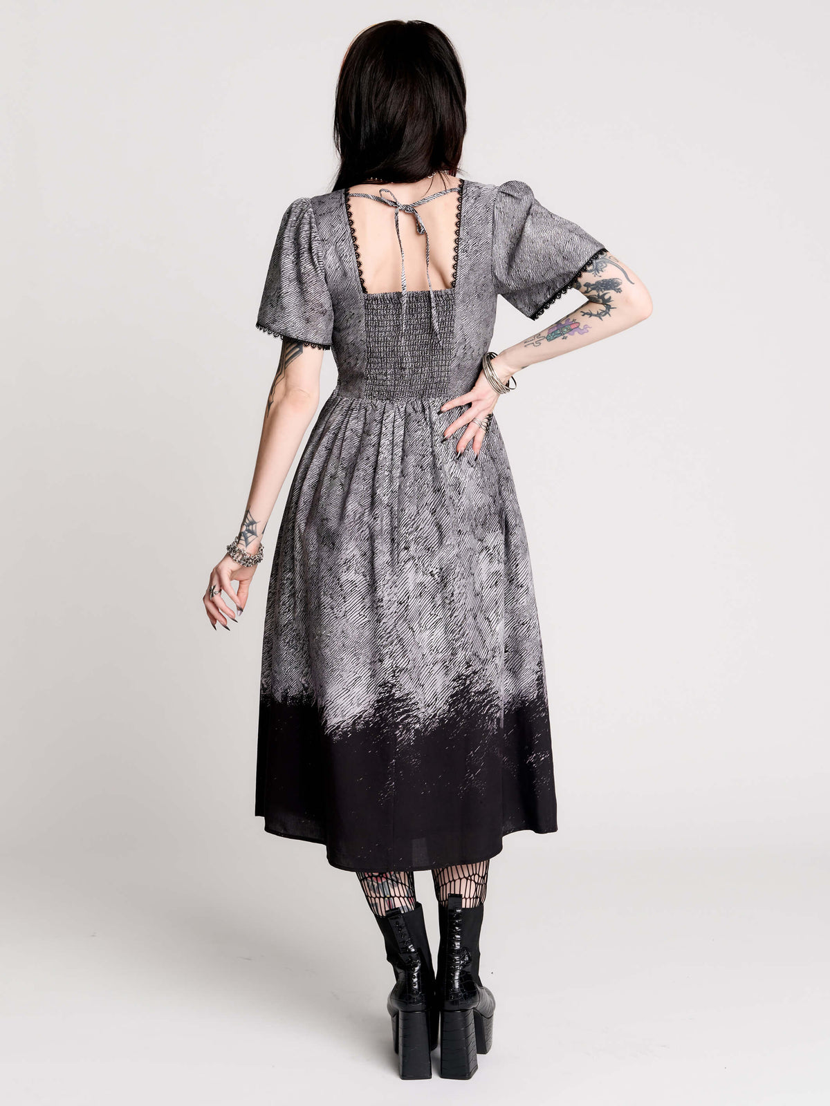 short-sleeved gray and black gothic-style midi dress with a printed illustration of a woman and winged figure at the hem