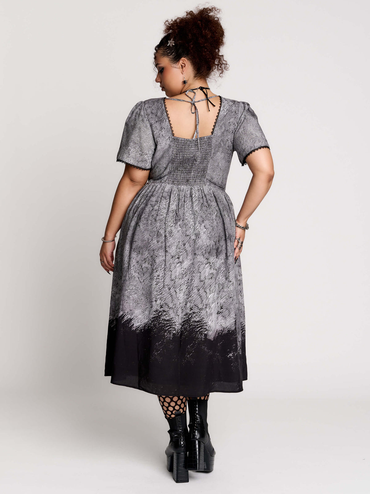 short-sleeved gray and black gothic-style midi dress with a printed illustration of a woman and winged figure at the hem