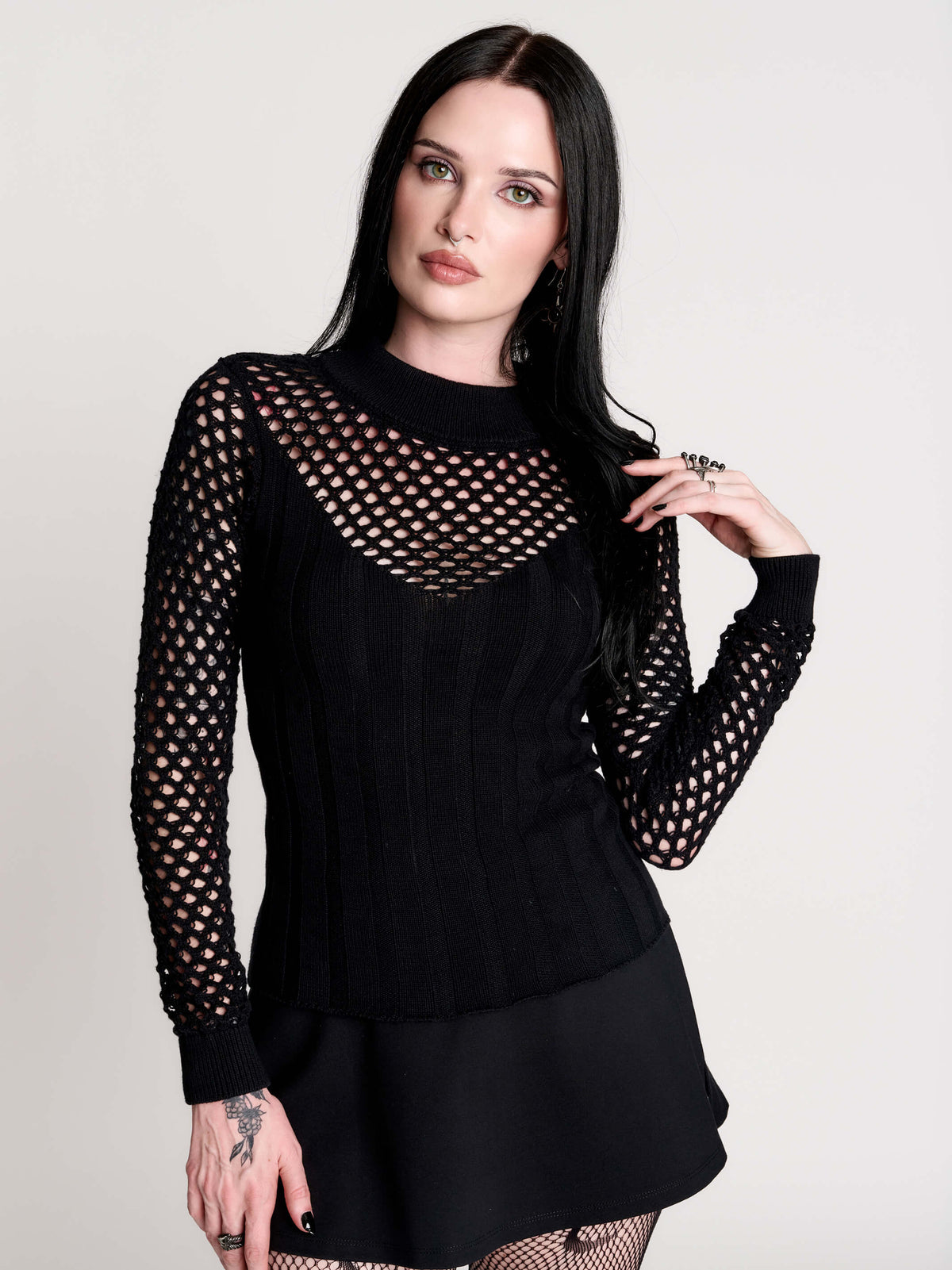Fishnet Sweetheart Rib Sweater, a black long-sleeve top with a fitted rib-knit body and fishnet across the upper chest, shoulders, upper back and sleeves, giving a “sweetheart” illusion while keeping the sleek silhouette sleek.
