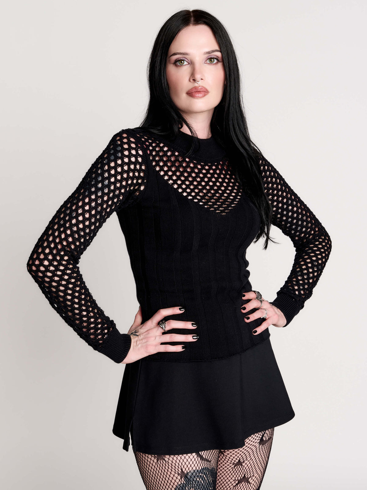 Fishnet Sweetheart Rib Sweater, a black long-sleeve top with a fitted rib-knit body and fishnet across the upper chest, shoulders, upper back and sleeves, giving a “sweetheart” illusion while keeping the sleek silhouette sleek.