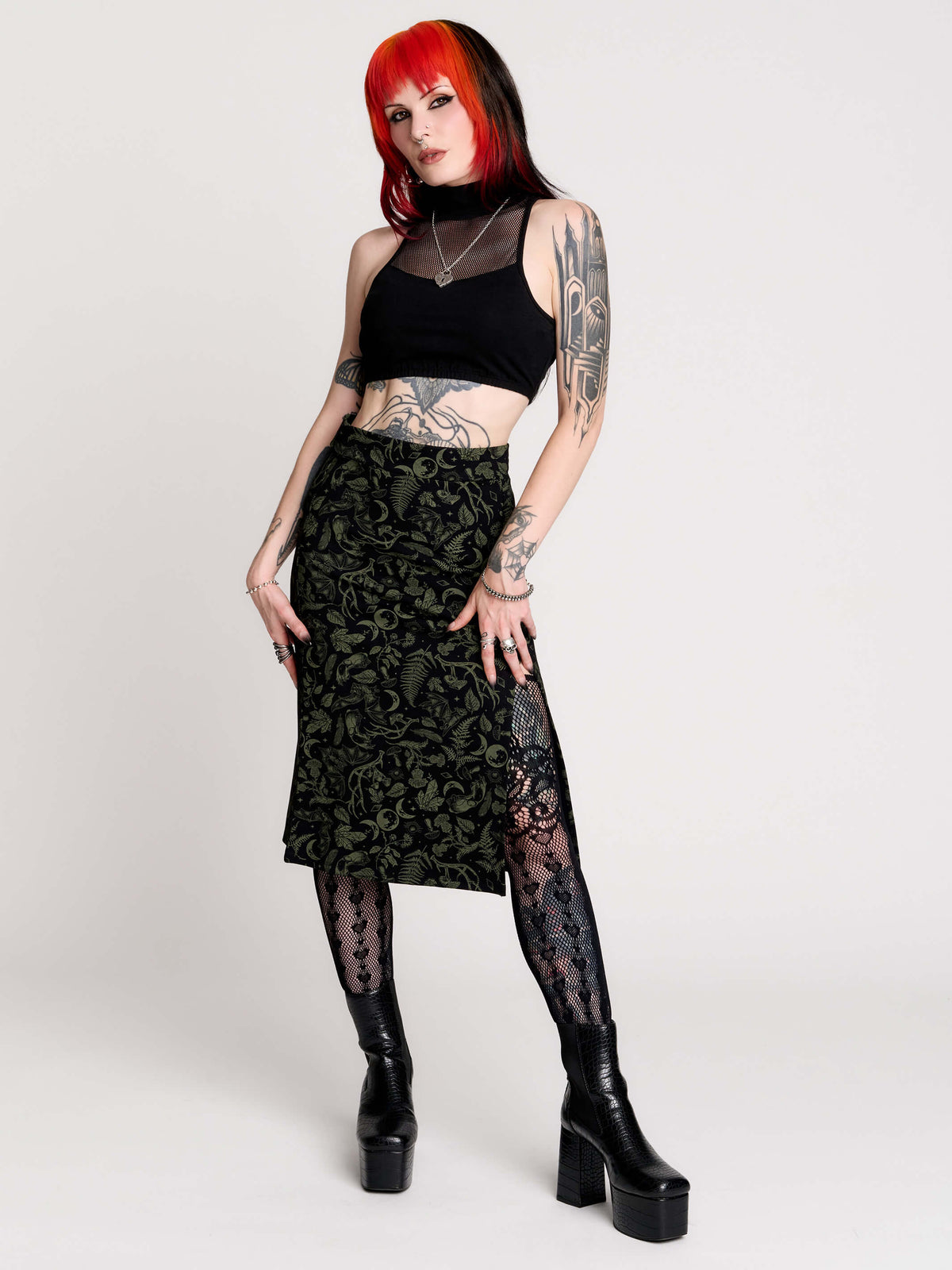 a black midi skirt with a green forest findings print.