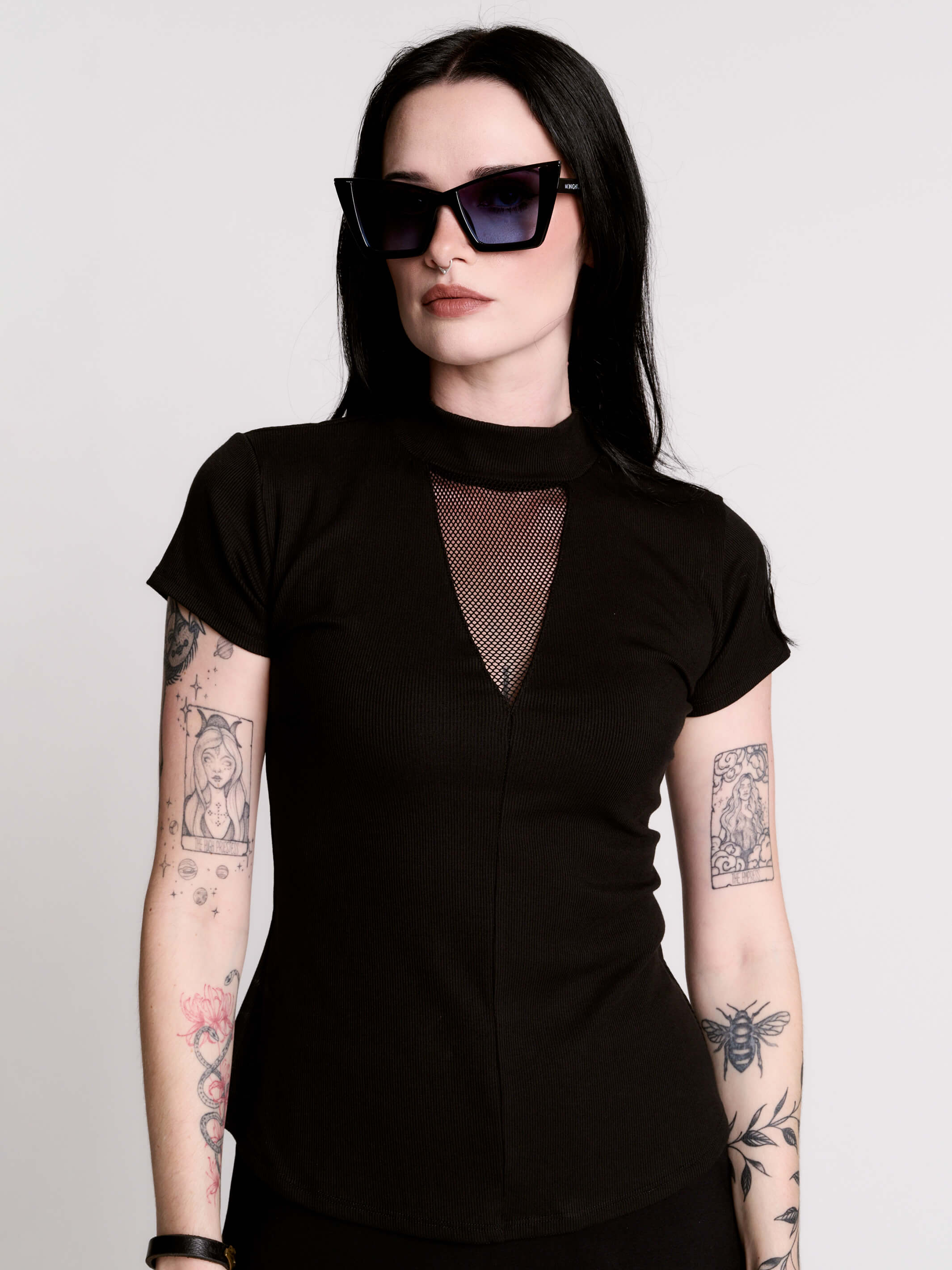 A black short-sleeve mock neck top with a fishnet mesh chest panel.