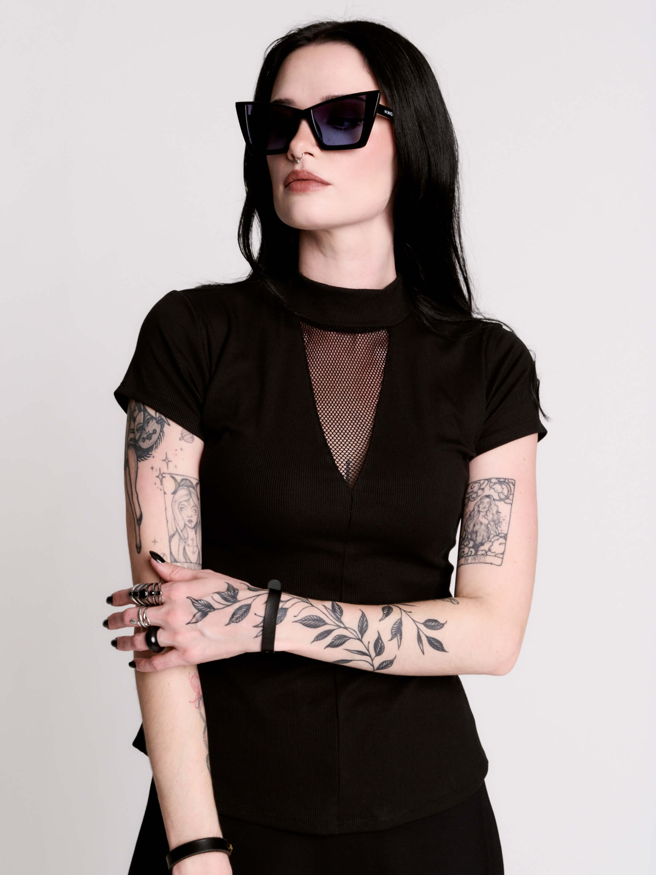 A black short-sleeve mock neck top with a fishnet mesh chest panel.