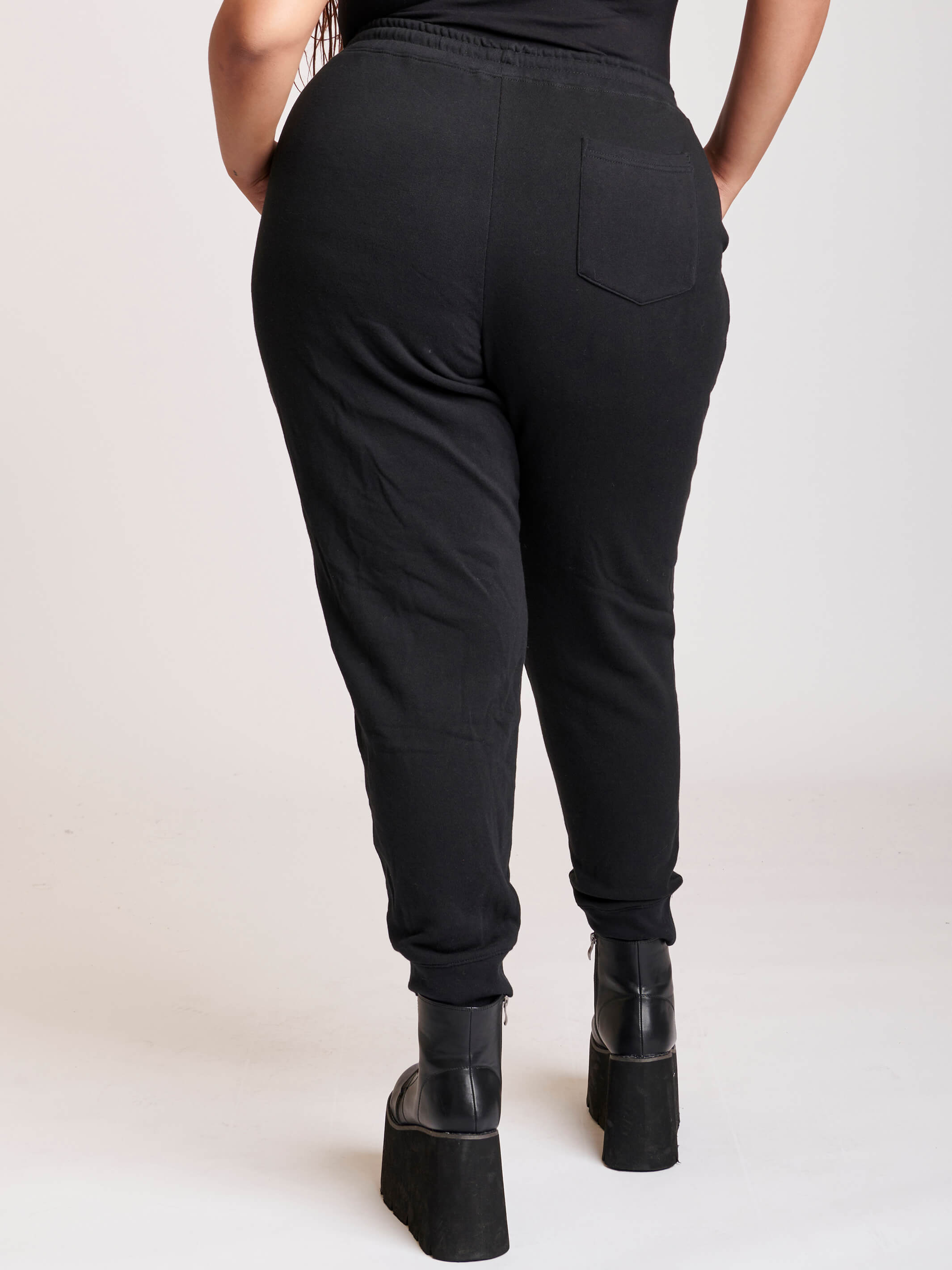 Black jogger with white rose and cresecent moon art at knees