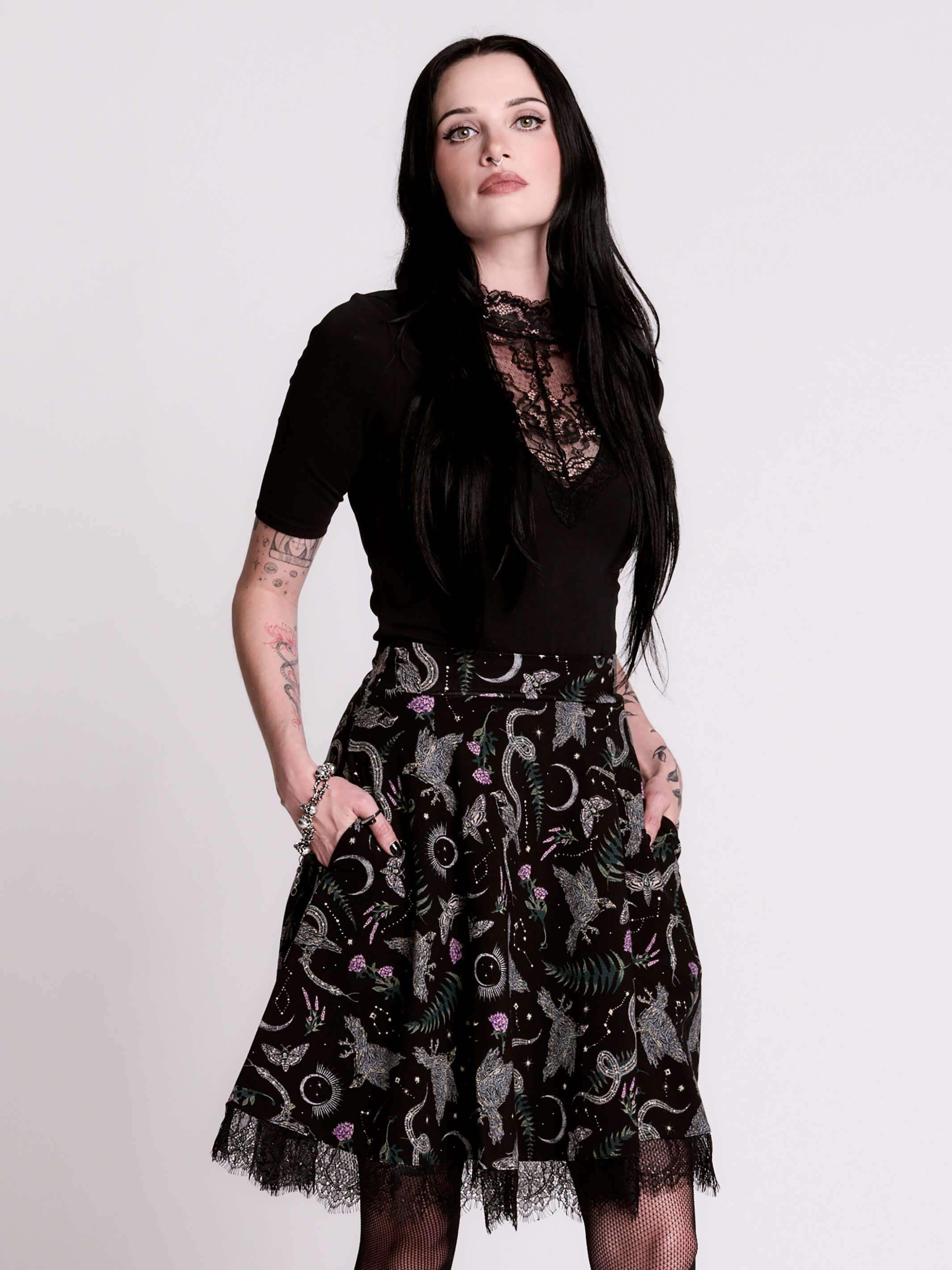 A black flared skirt featuring a gray and purple gothic print with lace hem.