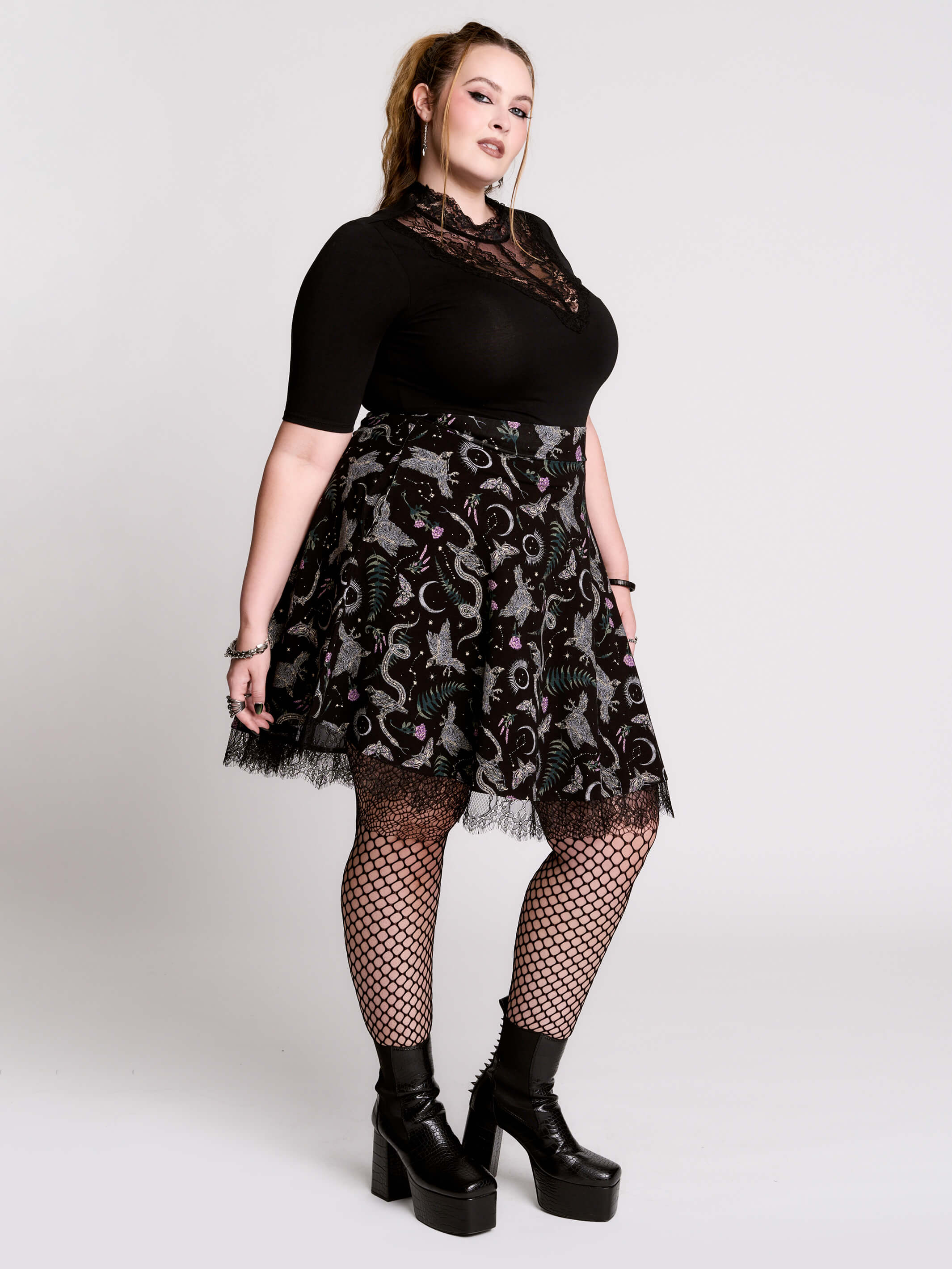 A black flared skirt featuring a gray and purple gothic print with lace hem.
