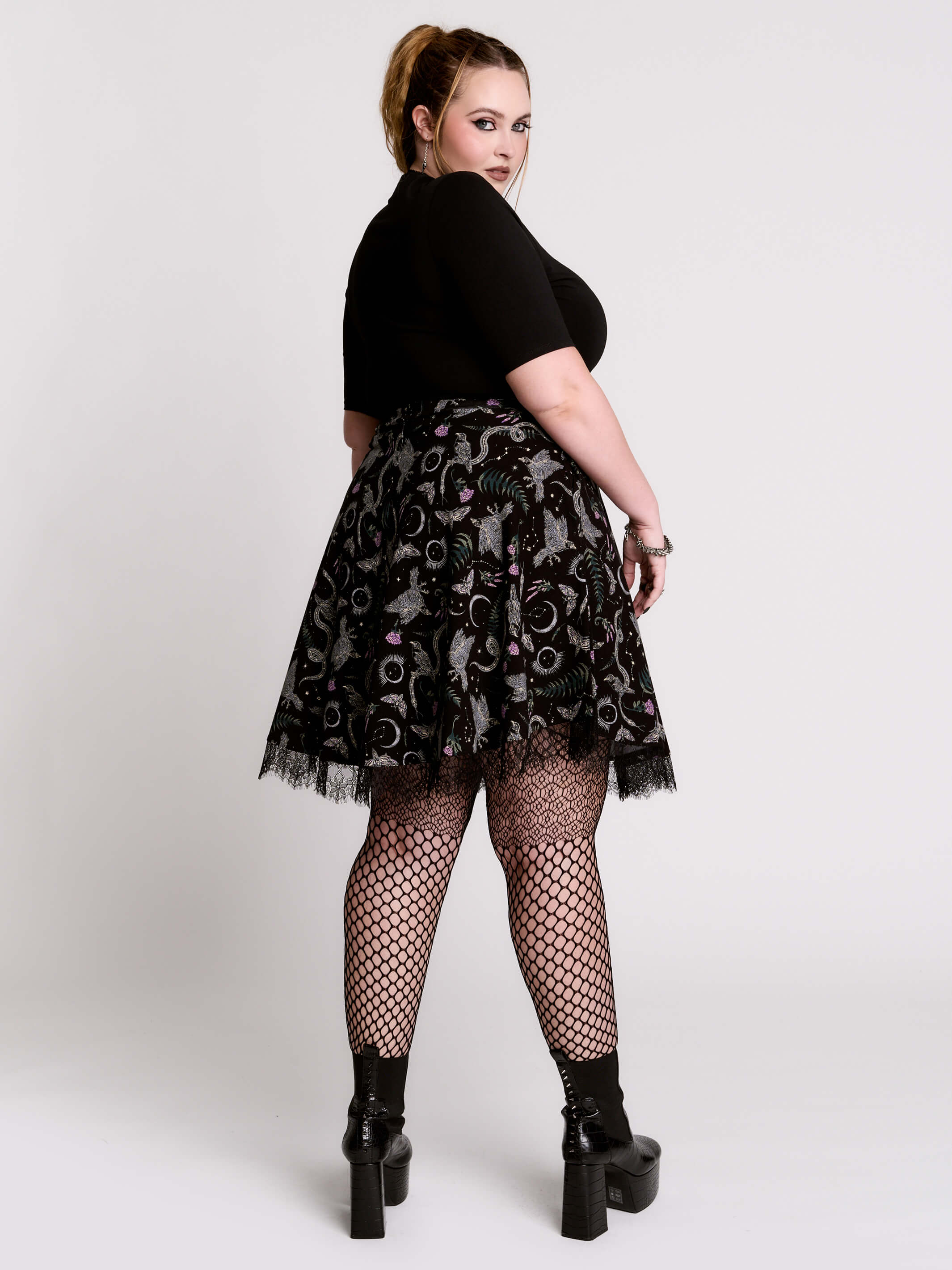 A black flared skirt featuring a gray and purple gothic print with lace hem.