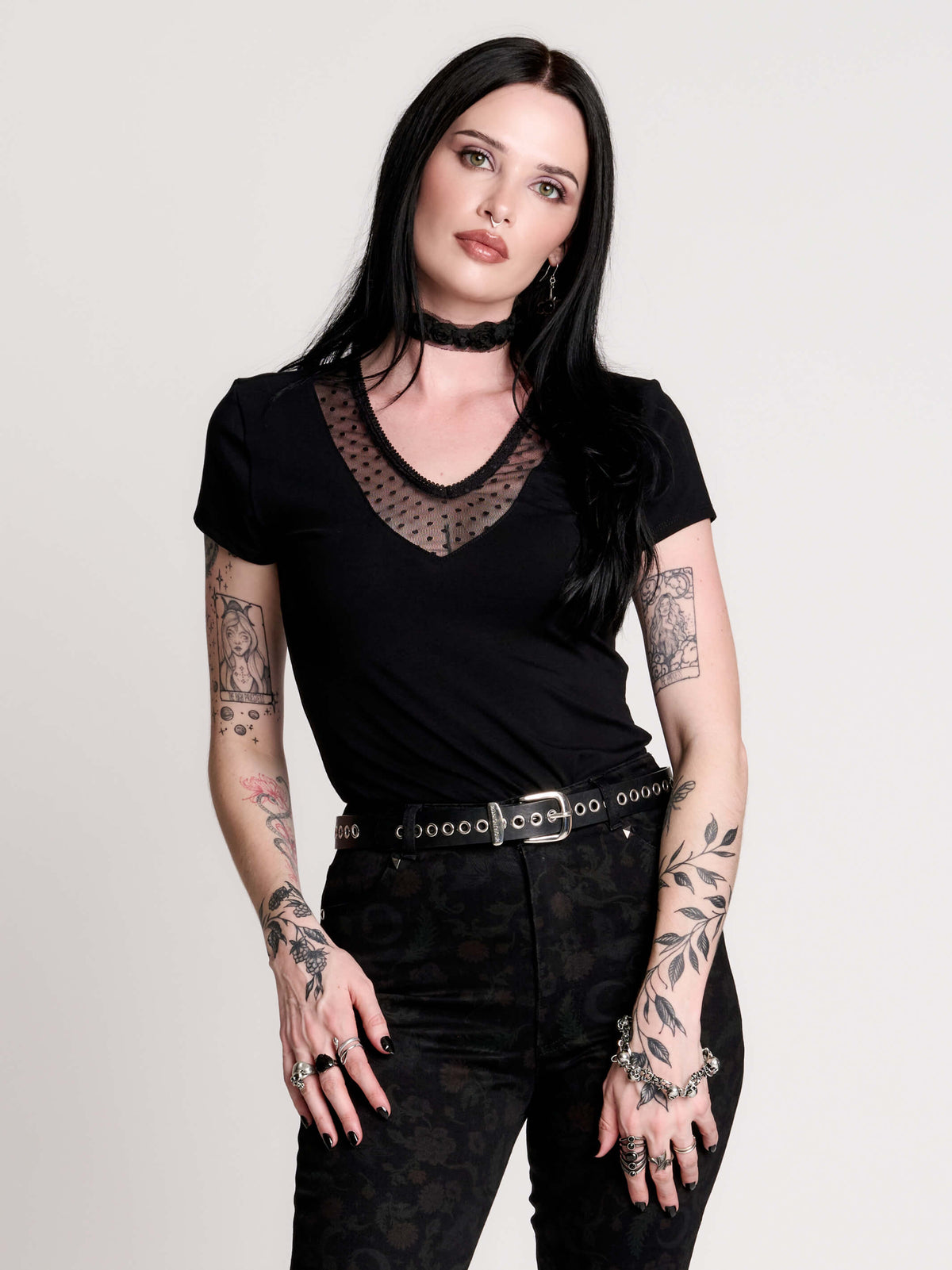 a black short-sleeve V-neck t-shirt featuring a sheer polka-dot mesh panel at the neckline
