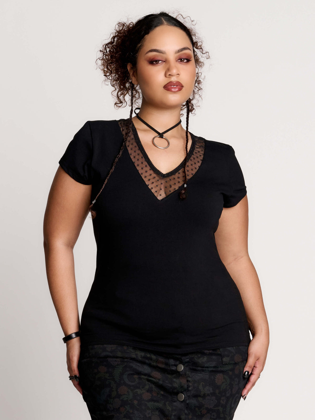 a black short-sleeve V-neck t-shirt featuring a sheer polka-dot mesh panel at the neckline