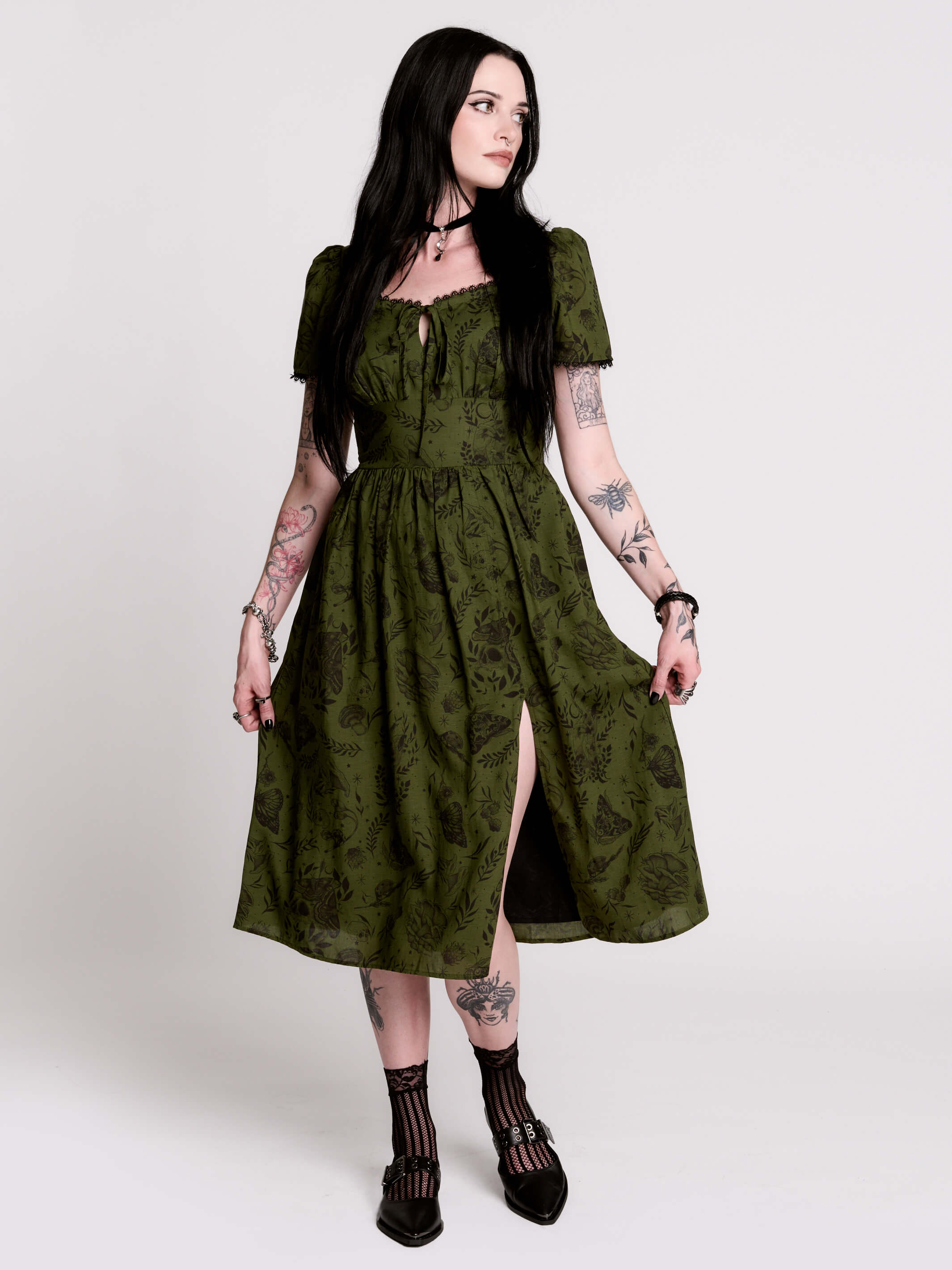 a short-sleeved olive green midi dress with a gothic pattern