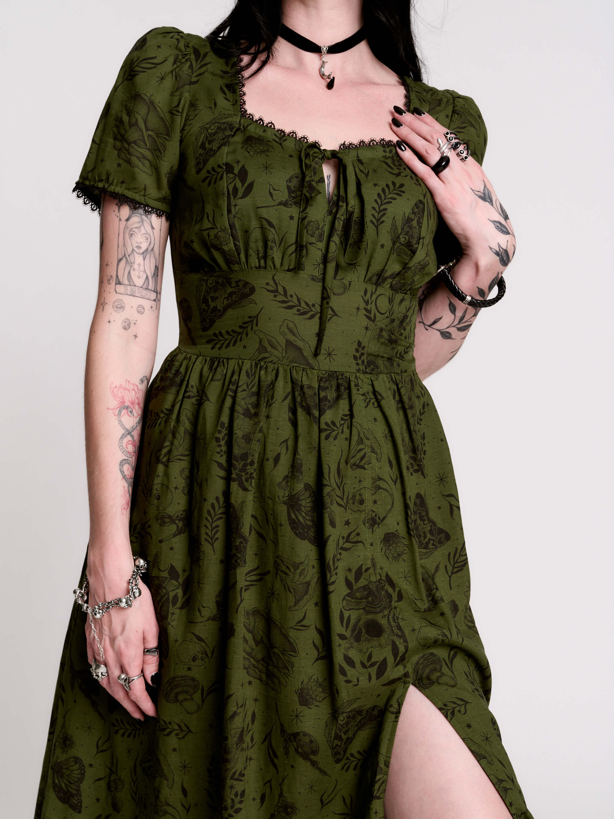 a short-sleeved olive green midi dress with a gothic pattern