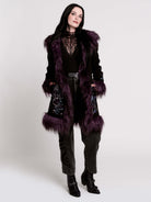 This mid-length black coat pairs a soft, suede-like finish with plush amethyst-purple faux fur trim