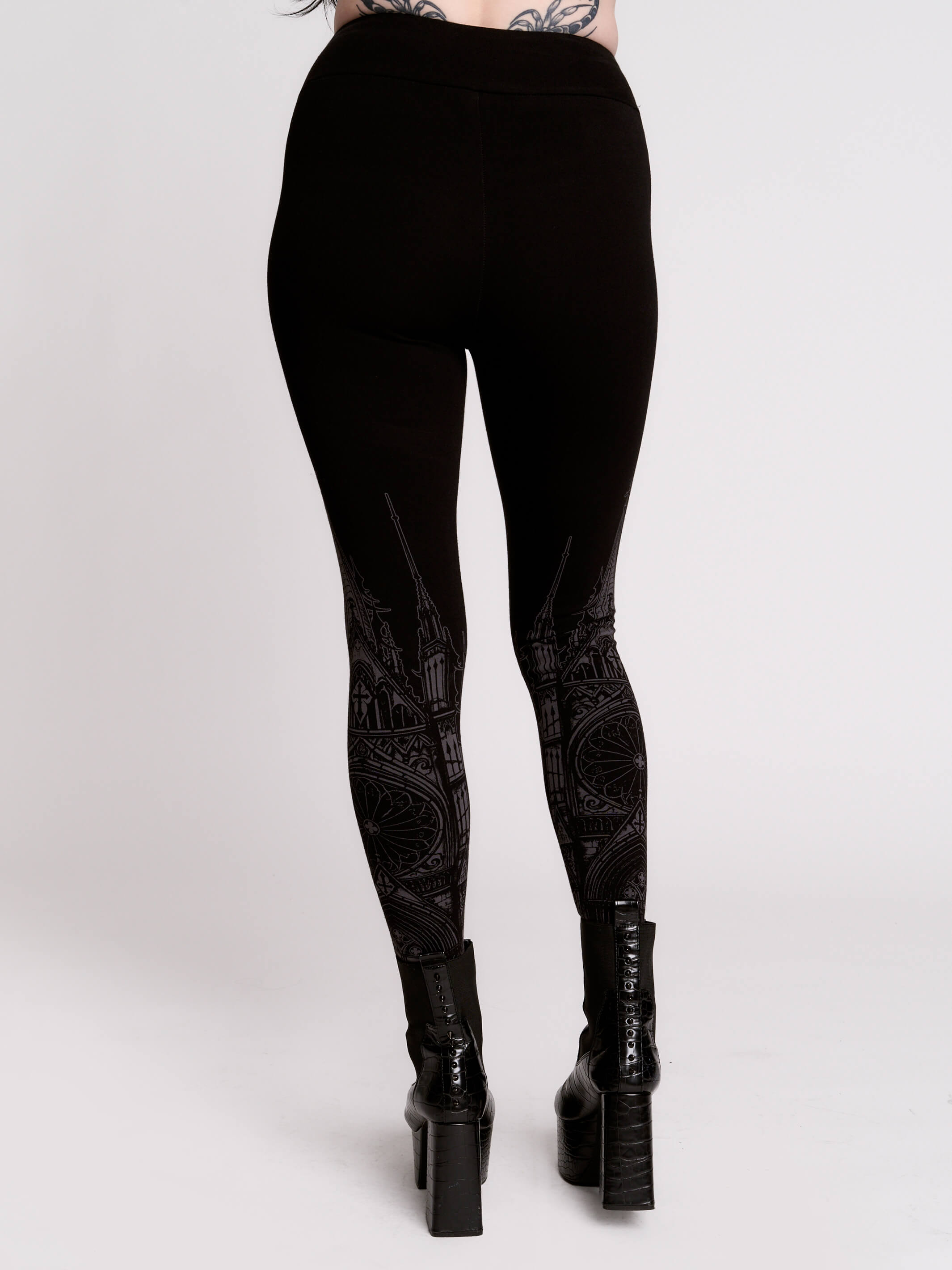 Black leggings with a dark gray gothic cathedral line-art print down the legs.