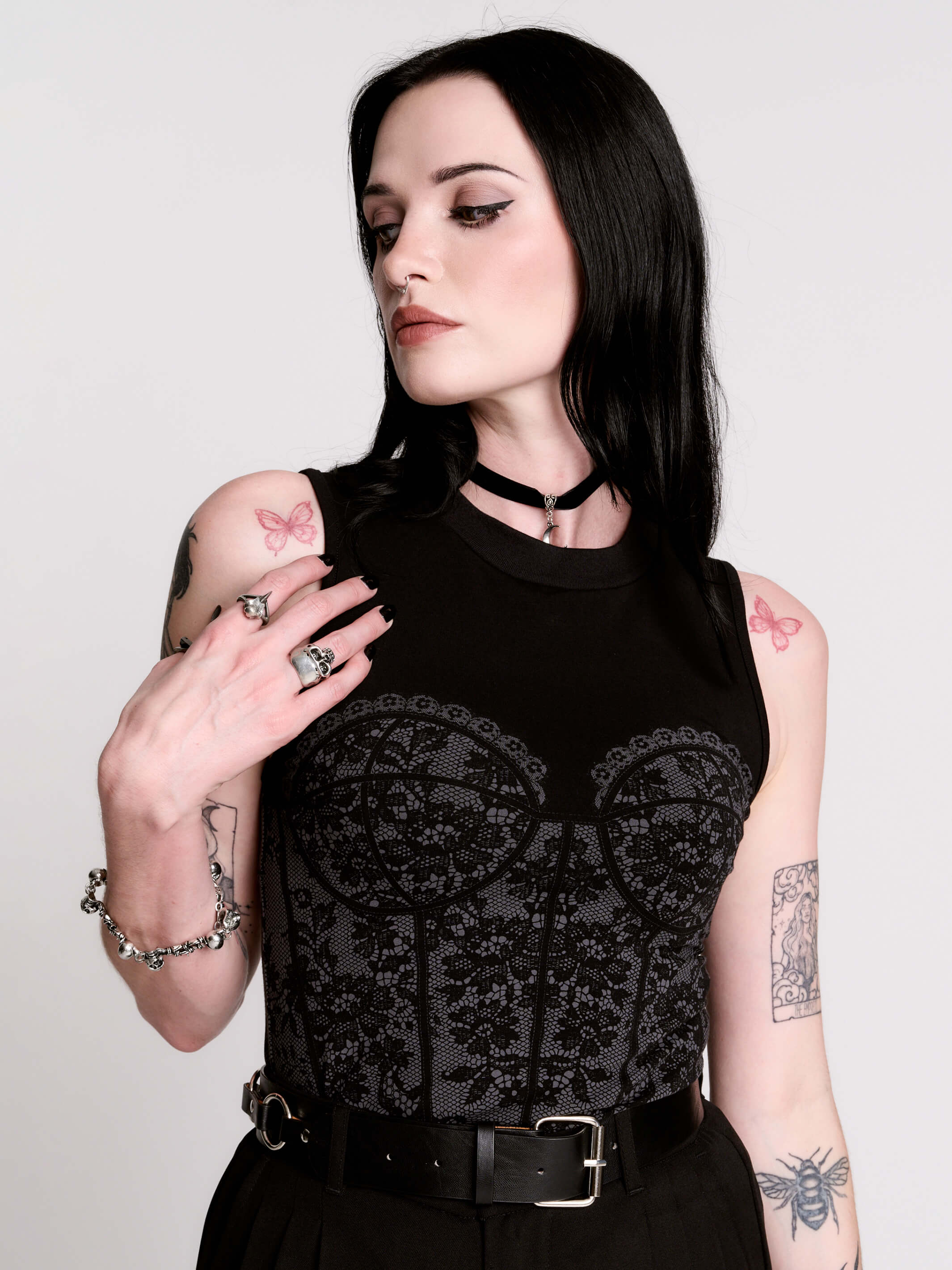 A black sleeveless top with a printed floral lace corset in light grey.