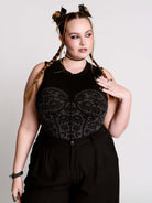 A black sleeveless top with a printed floral lace corset in light grey.
