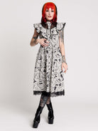 black and white gothic-style dress with a bird pattern, lace trim, and a high ruffled collar