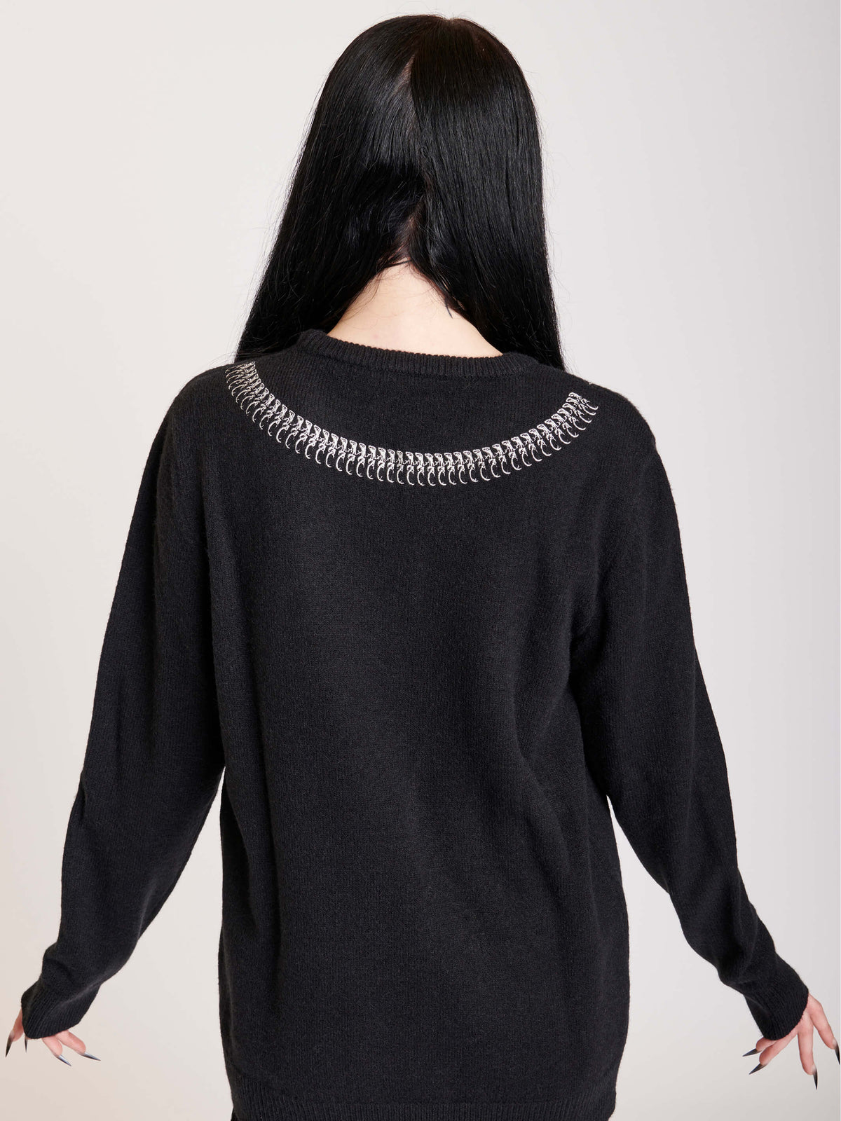 sweater with skeleton snake detail around neck.