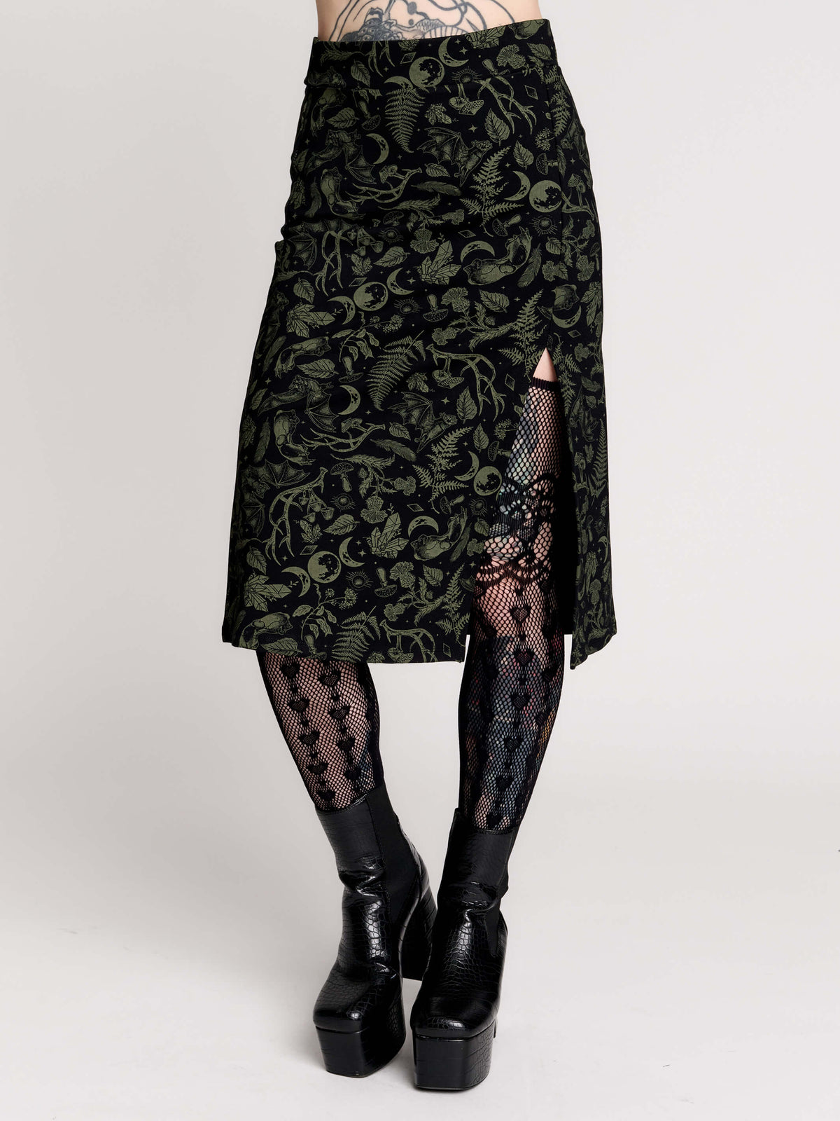 a black midi skirt with a green forest findings print. 