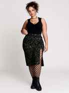 a black midi skirt with a green forest findings print. 