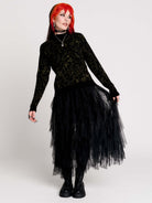 a black long-sleeve top with an intricate olive green forest findings pattern