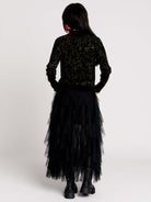 a black long-sleeve top with an intricate olive green forest findings pattern