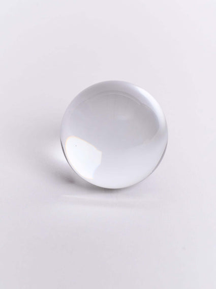 a clear glass ball on a white surface