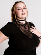 A black short-sleeve dress with a lace V-neckline.
