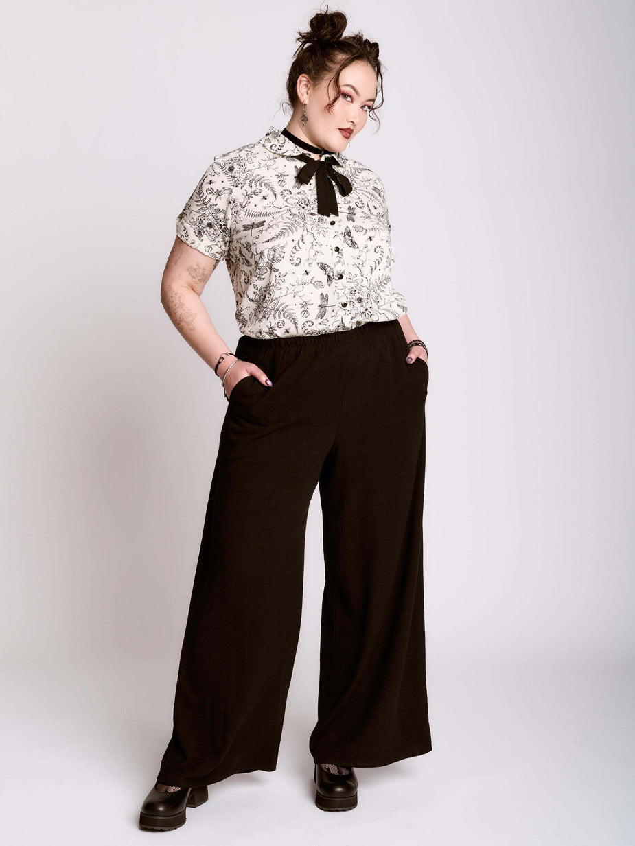 a woman in a white shirt and black pants