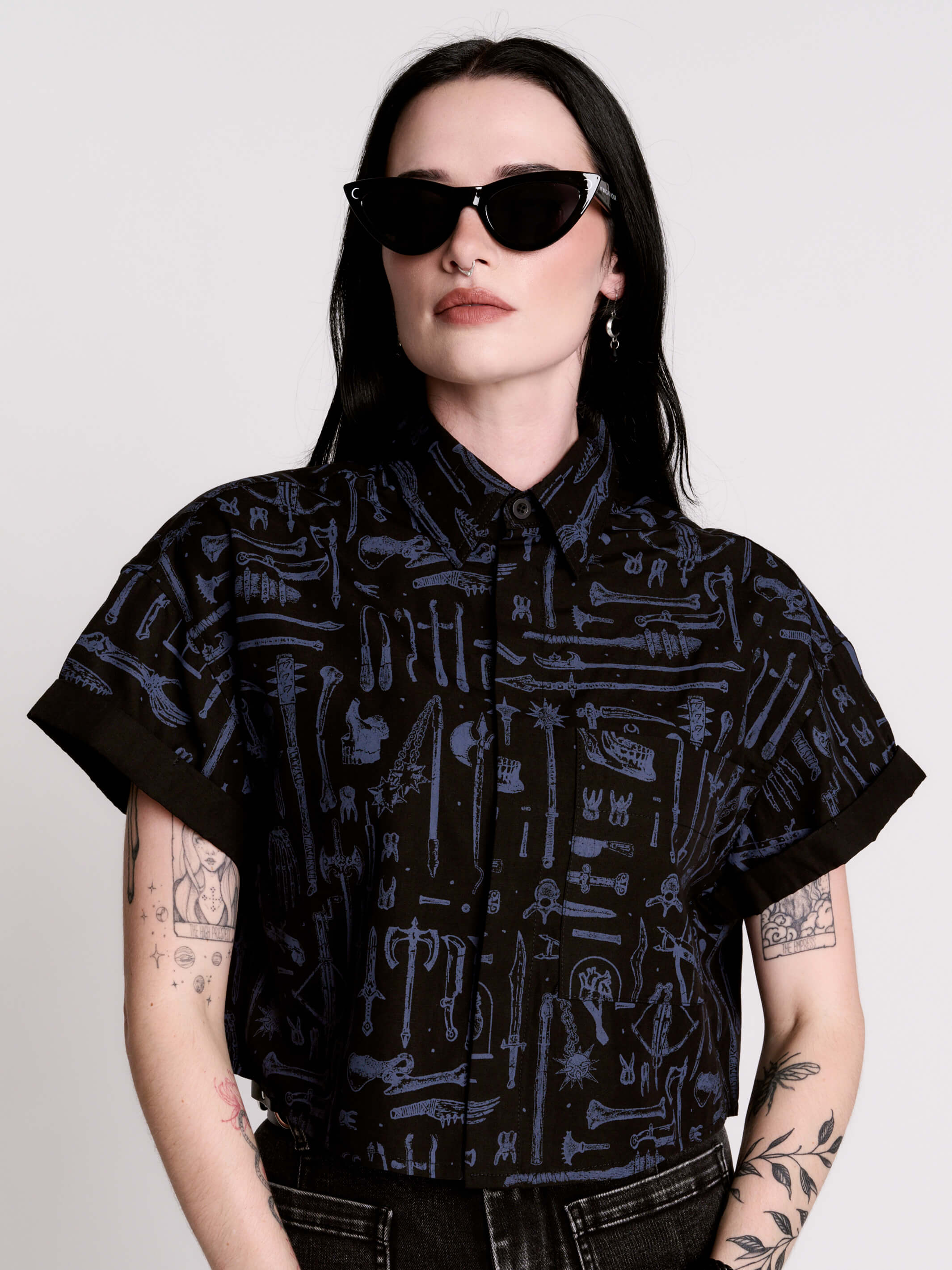 Armory Cropped Shirt is a boxy, cropped, short-sleeve button-down that mixes crisp classic shirting with dark, gothic illustration. 