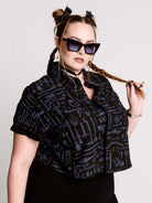 Armory Cropped Shirt is a boxy, cropped, short-sleeve button-down that mixes crisp classic shirting with dark, gothic illustration. 