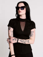A black short-sleeve mock neck top with a fishnet mesh chest panel.