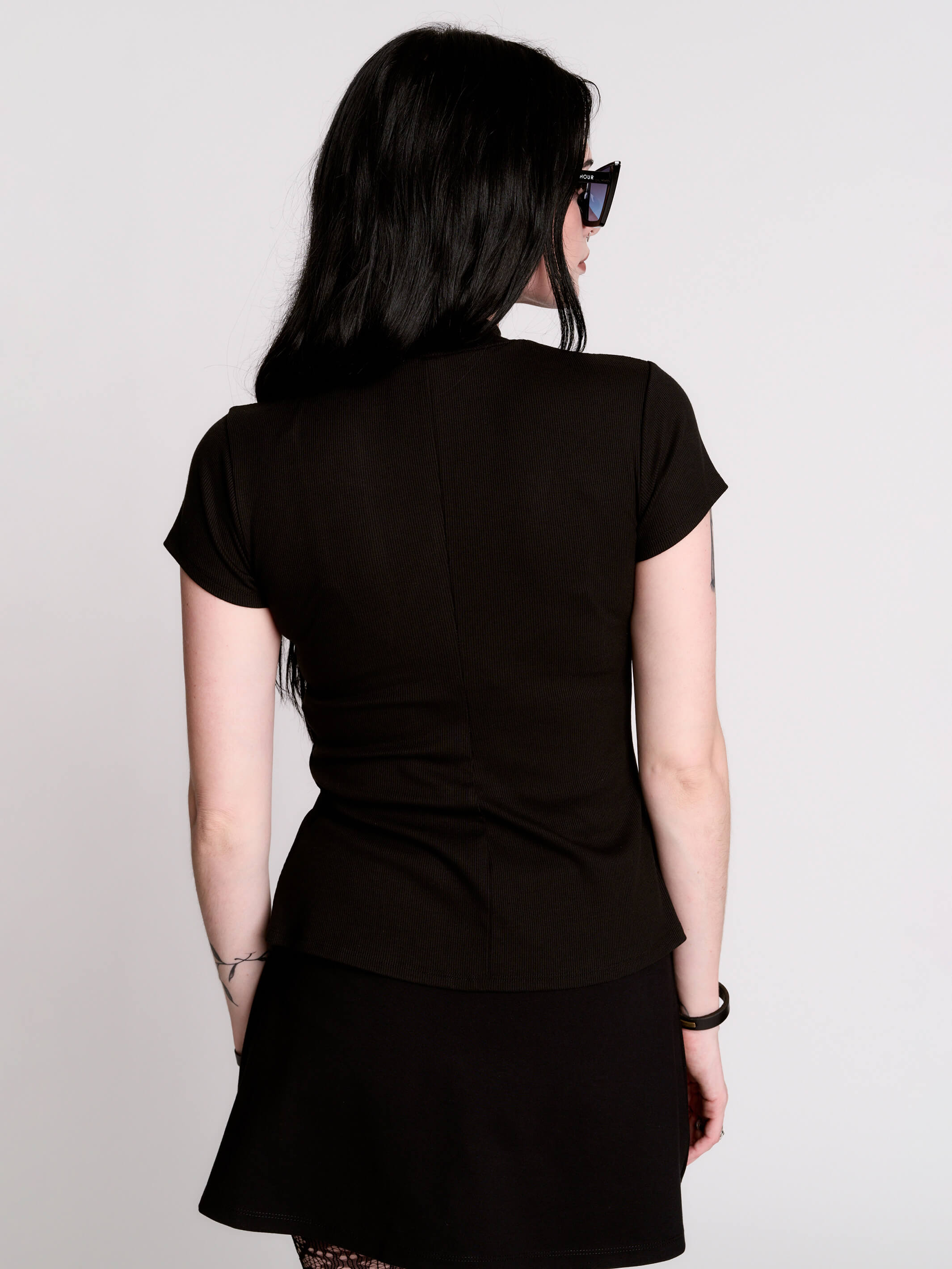 A black short-sleeve mock neck top with a fishnet mesh chest panel.