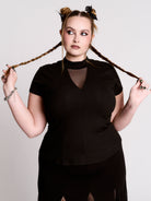 A black short-sleeve mock neck top with a fishnet mesh chest panel.