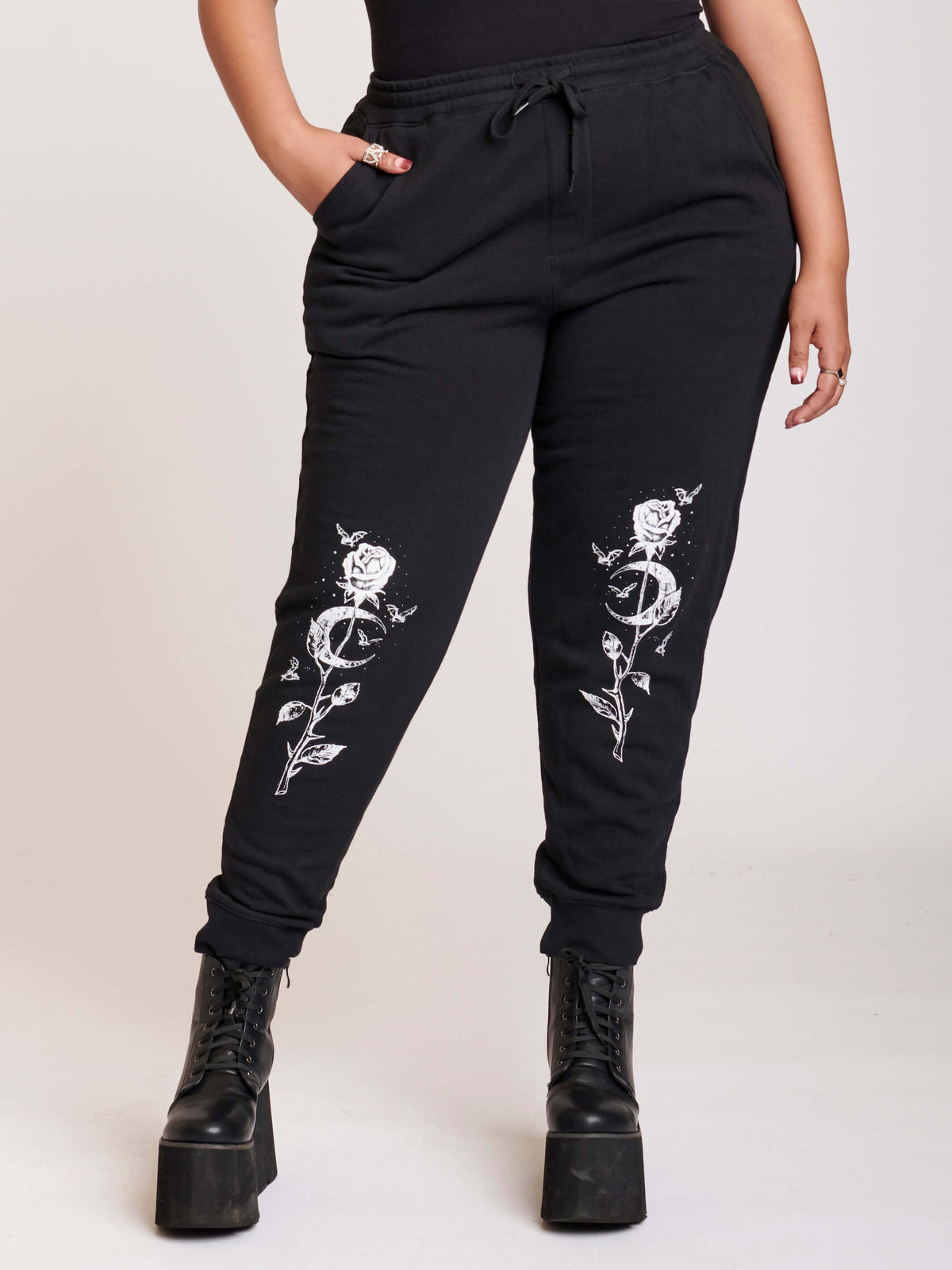 Black jogger with white rose and cresecent moon art at knees