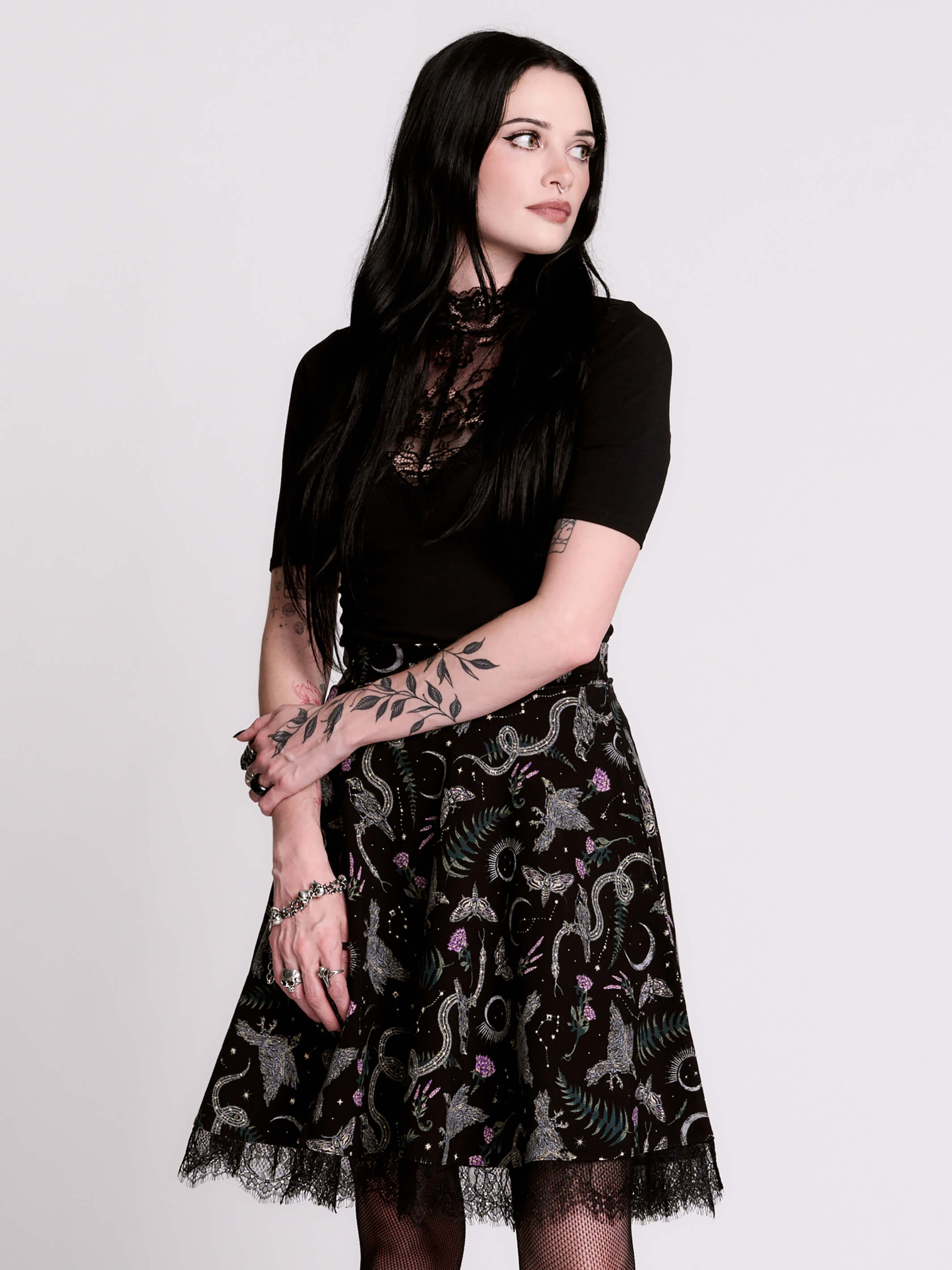 A  black flared skirt featuring a gray and purple gothic print with lace hem.