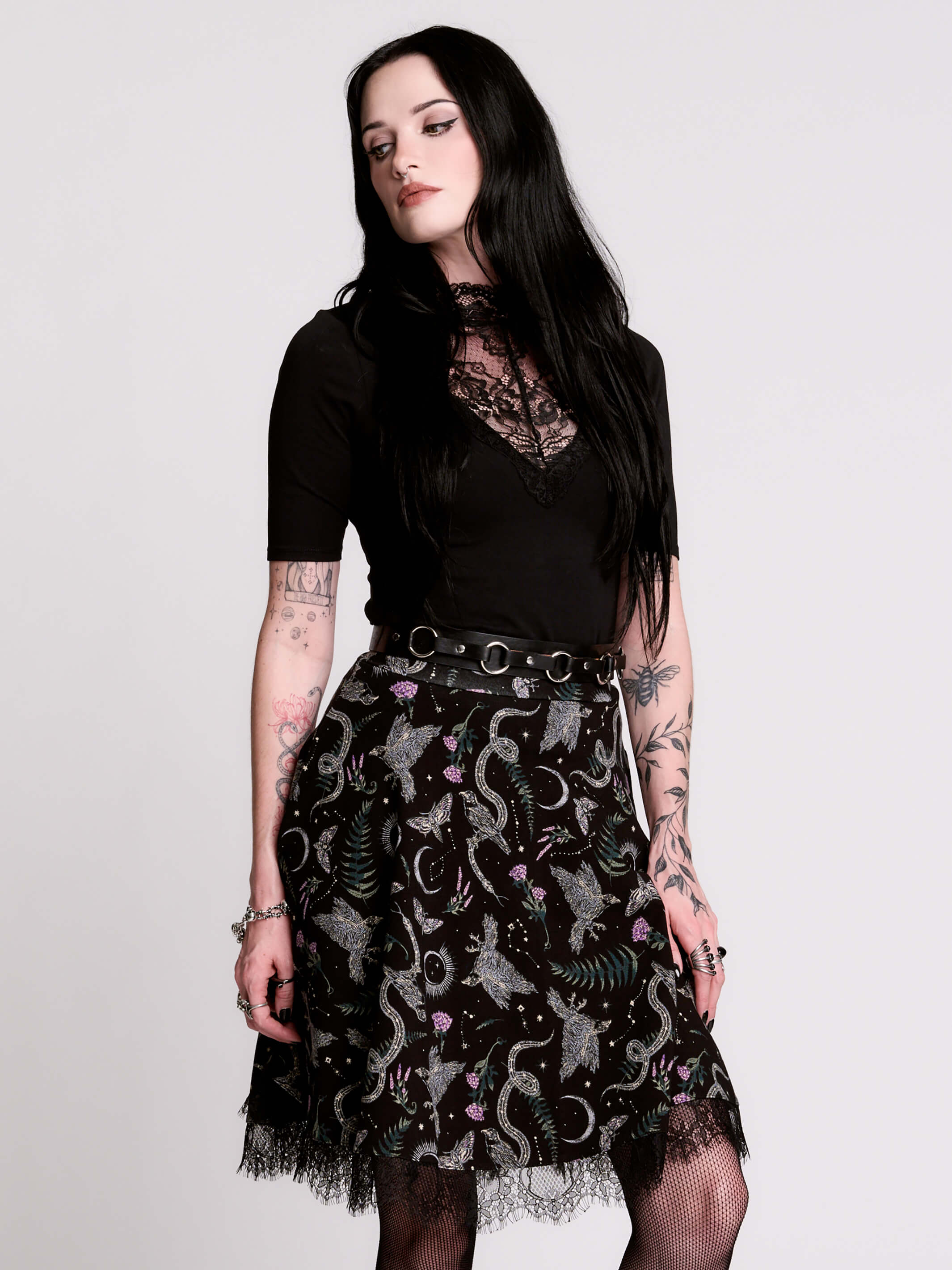 A  black flared skirt featuring a gray and purple gothic print with lace hem.