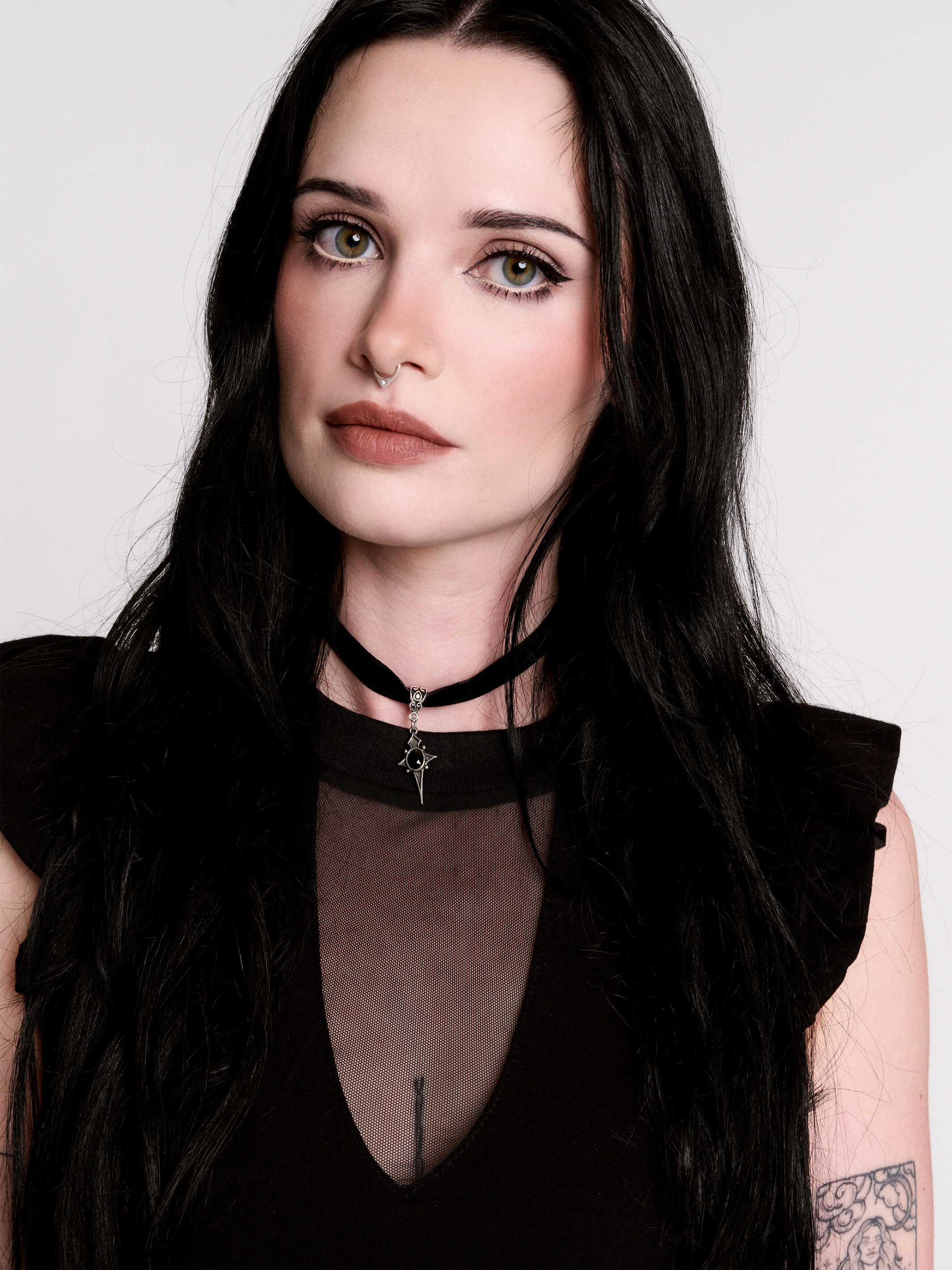 A black ruffled sleeveless top with a sheer chest cutout.