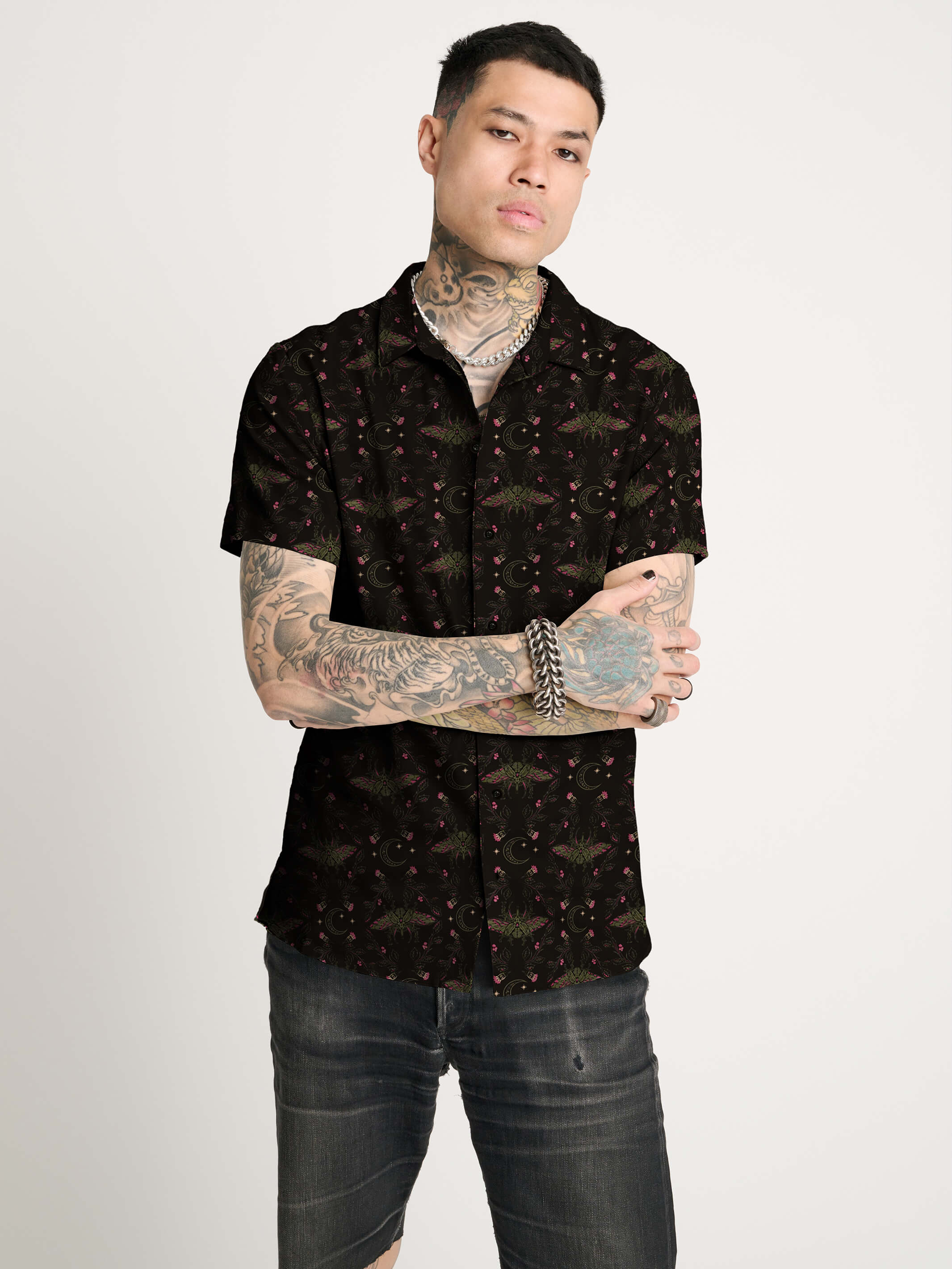A black short-sleeve button-up shirt with  repeating red and green scarab beetle pattern.