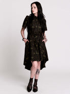 a short-sleeved high-low dress in black with a small red and green floral pattern.
