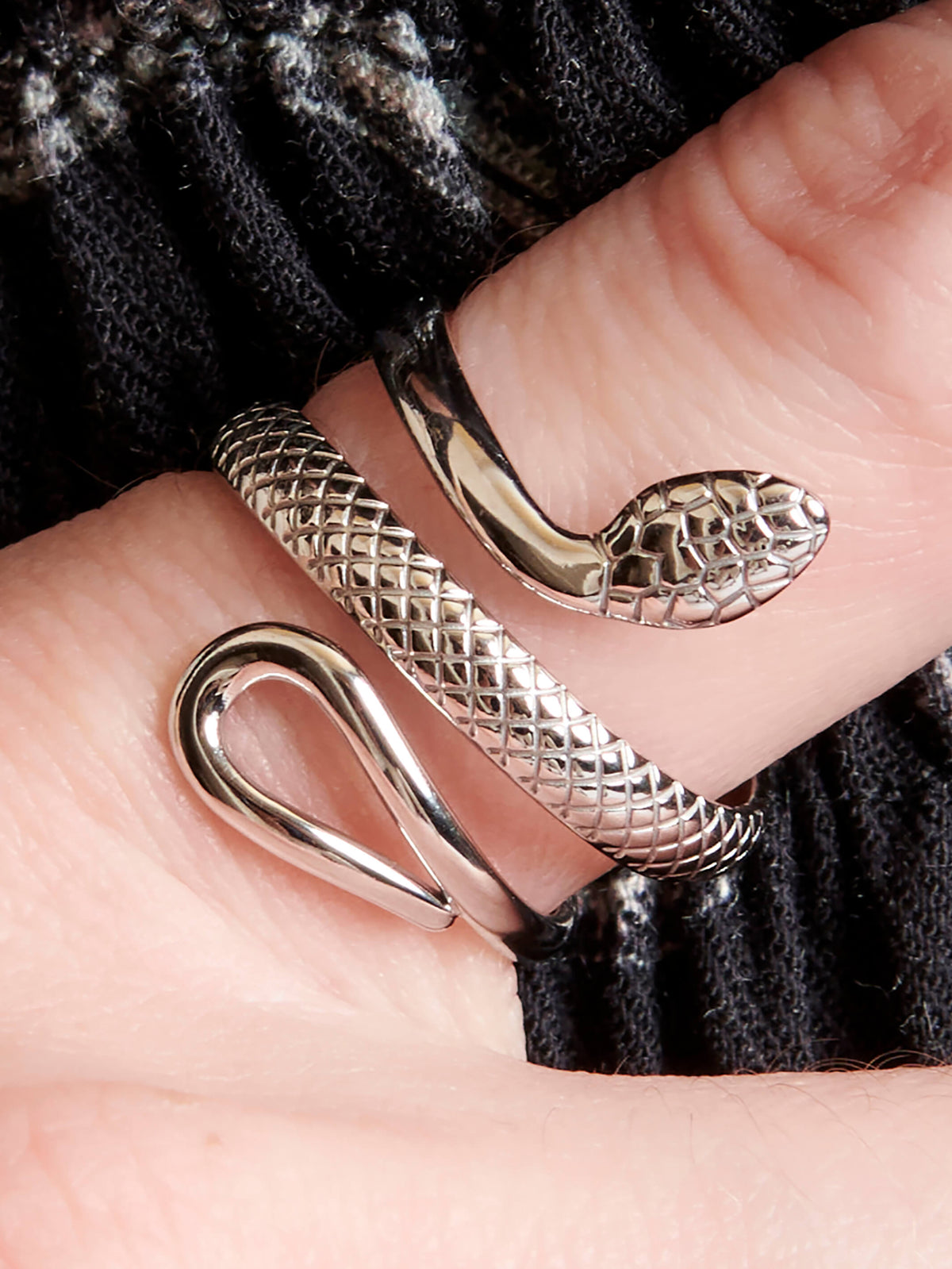 Silver snake wrapping around finger