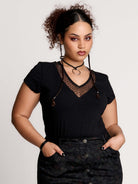 a black short-sleeve V-neck t-shirt featuring a sheer polka-dot mesh panel at the neckline