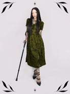 a short-sleeved olive green midi dress with a gothic pattern