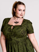 a short-sleeved olive green midi dress with a gothic pattern