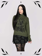 an olive green mock-neck sweater featuring a black gothic graphic