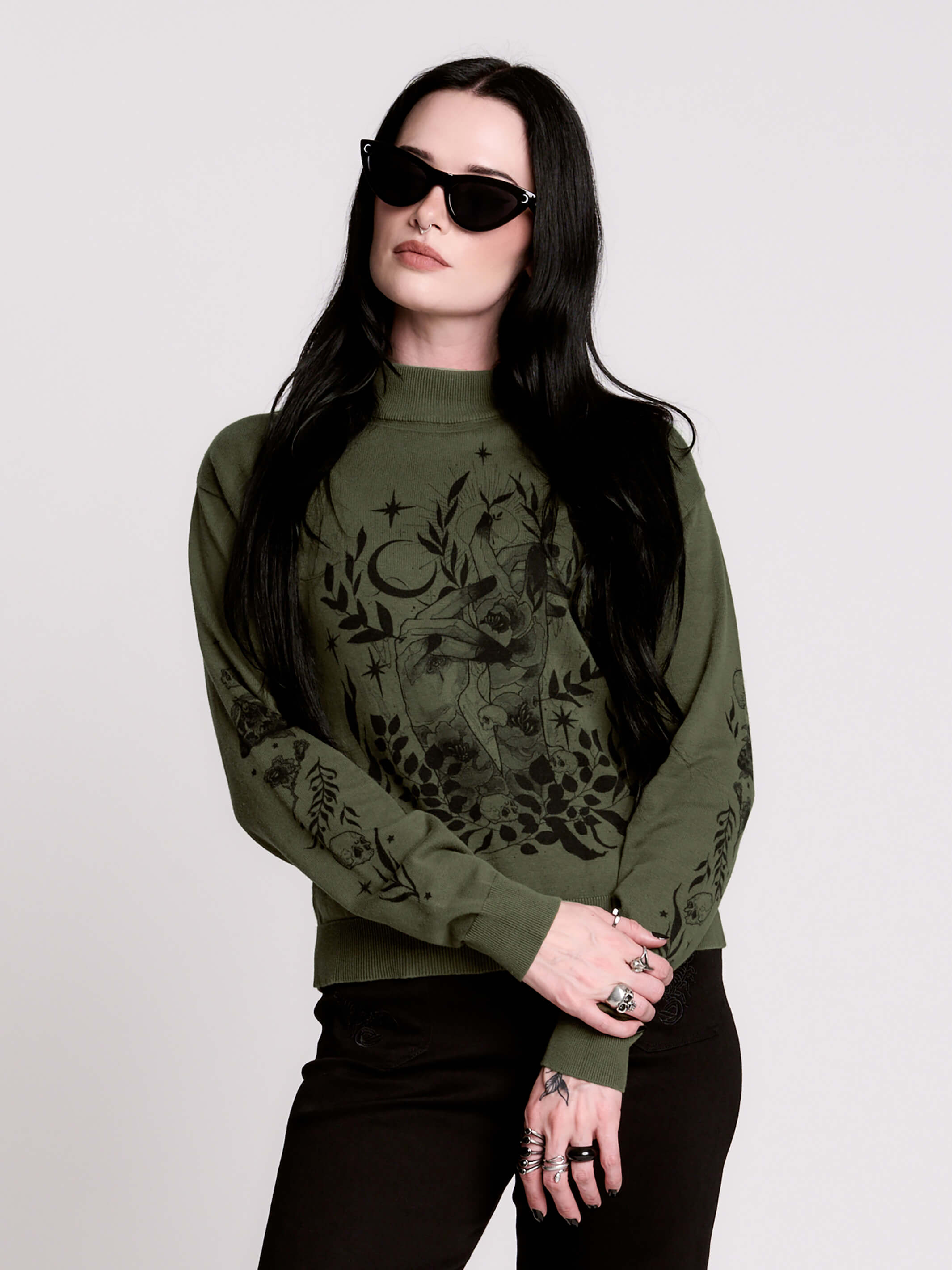 an olive green mock-neck sweater featuring a black gothic graphic