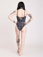 black one piece swim suit with a white all over print and lace up detail front and back middle
